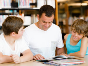 Father with sons in library