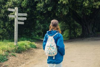 Woman looking at signpost in forest