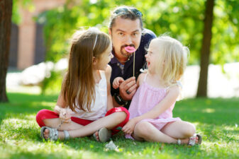 Dad goofing around with his daughters in the park