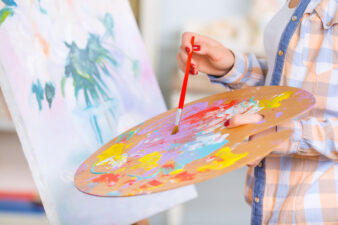 Person painting from palette onto canvas