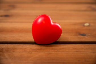 close up of red heart on wood table