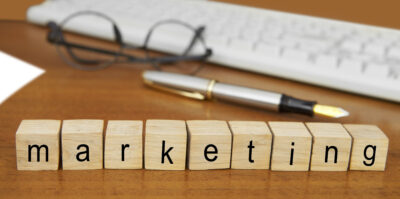 The word marketing spelled out in blocks on a desk