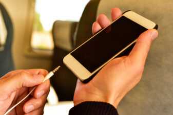 man plugging in headphone on train