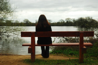 Woman sitting by a lake