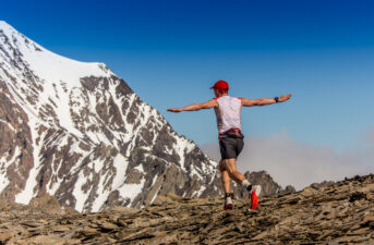 Man walking with arms spread on a mountain