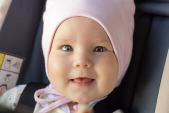 little newborn baby girl rests in the car seat