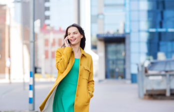 smiling woman walking and talking on her phone