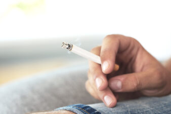 male hand holding a cigarette