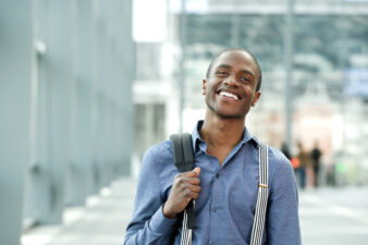 Smiling black man carrying a backpack