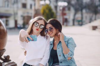 two girls taking a selfie outside