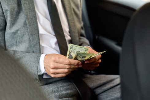 man counting dollar bills