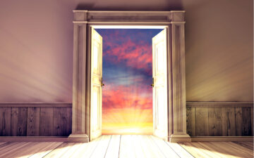 Empty room with a door opening to a beautiful sky