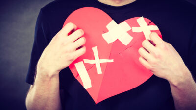 Man holding a patched together red heart