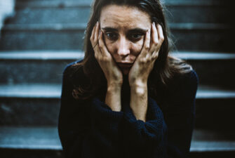 adult woman sitting on stairs looking scared