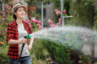 Woman watering her garden with a hose