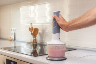 Person using blender on kitchen counter