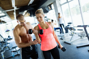 Male fitness trainer working with female client