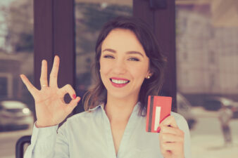 smiling woman looking happy about her credit card