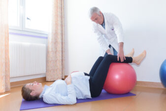 Pregnant woman with her legs propped up on an exercise ball in a birthing class