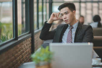 Young man looking out window at work