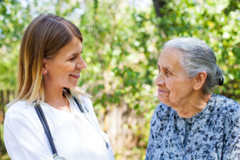 Elderly female speaking with kind younger nurse