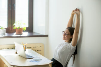 woman stretching at her desk