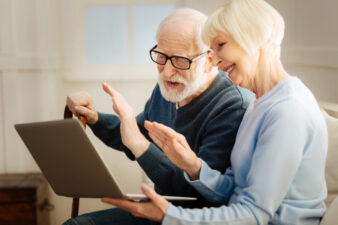 Cheerful blonde woman holding laptop