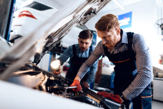 Two men working on car engine