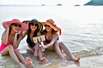 Three women sitting on the beach on vacation