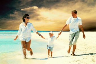 View of happy young family having fun on the beach