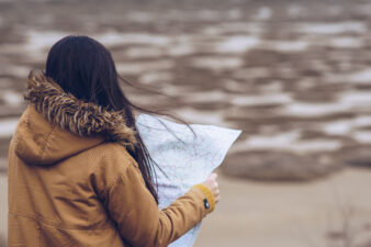 Woman reading a map in a dry landscape