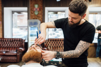 Man cutting another man's hair at barber shop