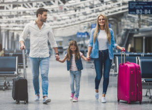 family traveling with luggage at the airport