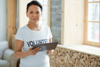 Attentive female volunteer using tablet