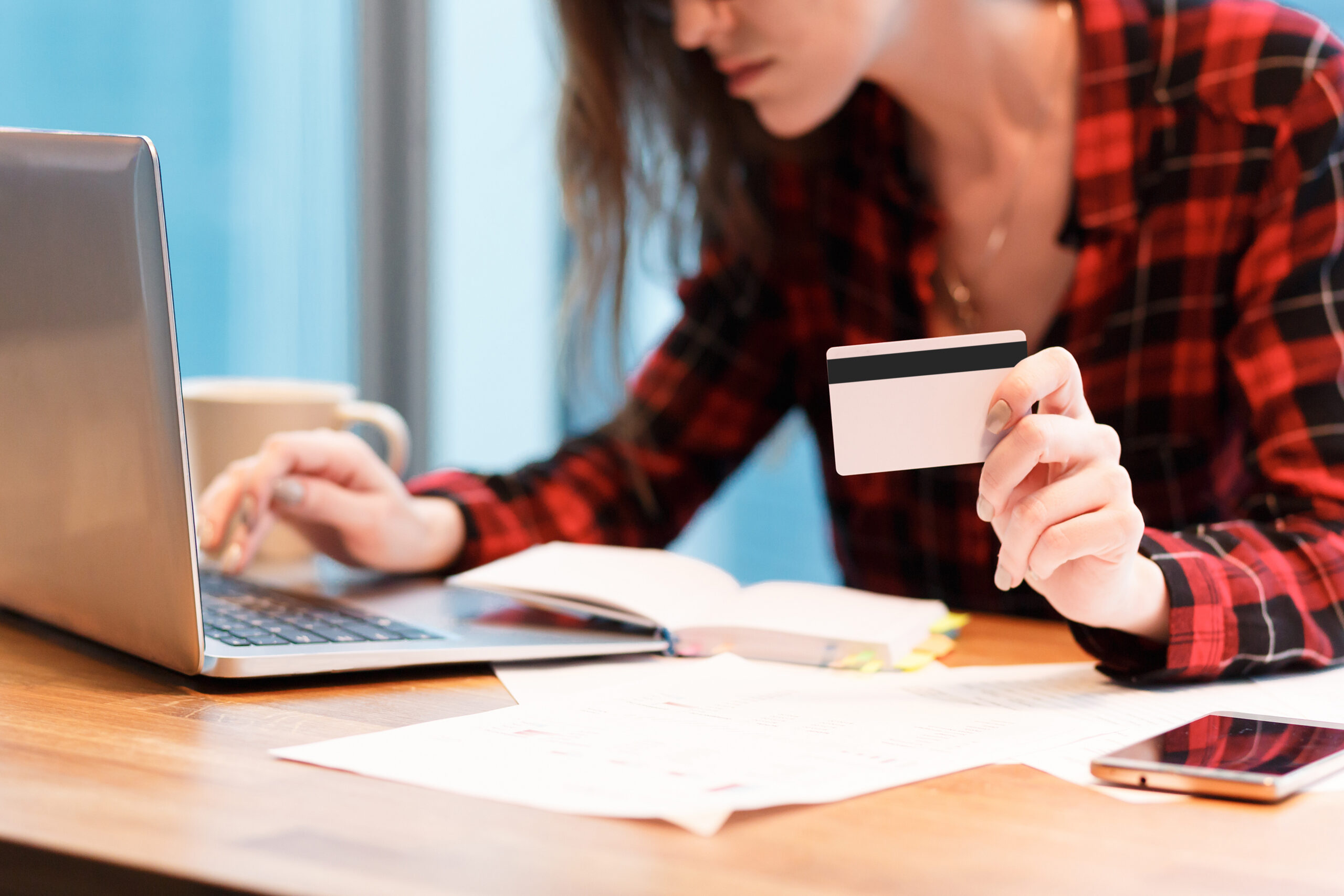 Payment for online purchases. Young unidentified woman in everyday clothes pays for purchases in an online store using card