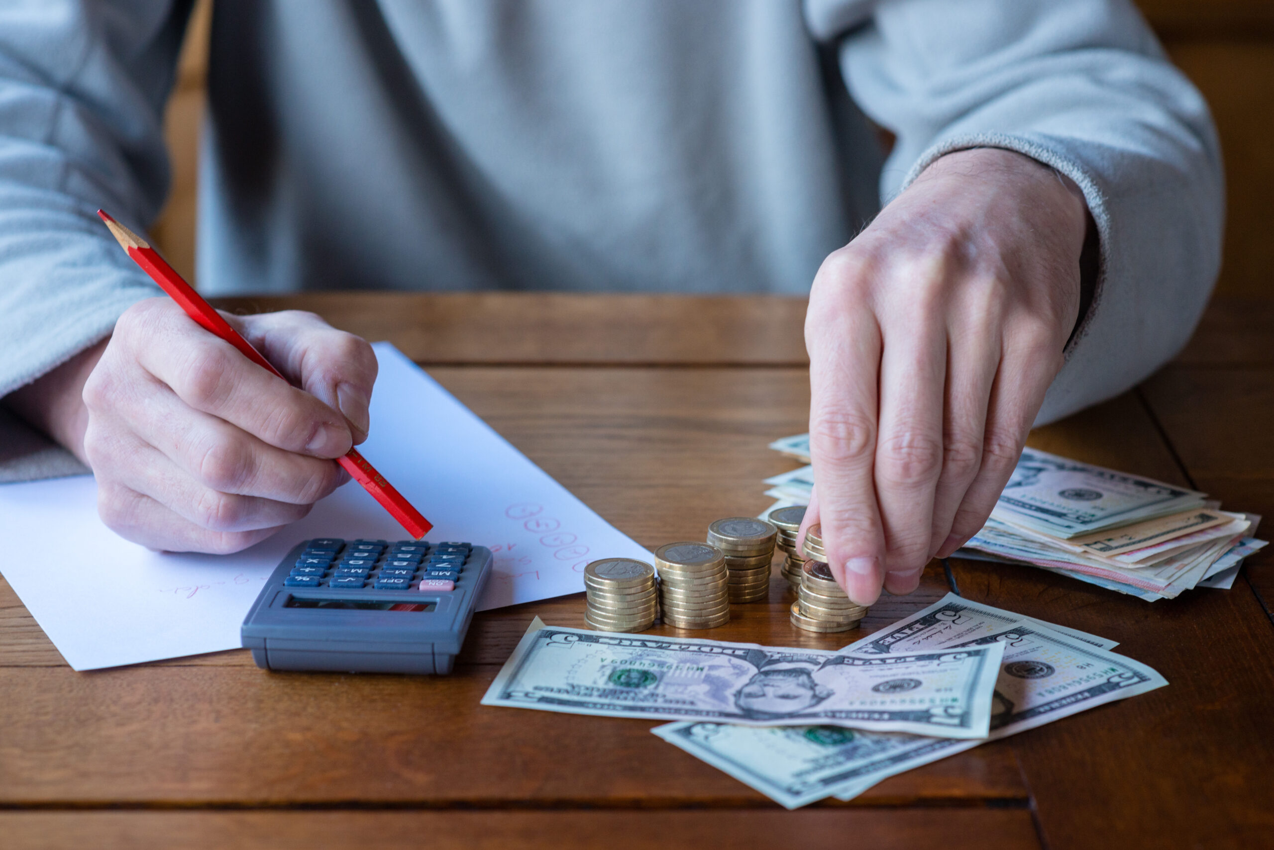 Close up man with calculator counting, making notes at home