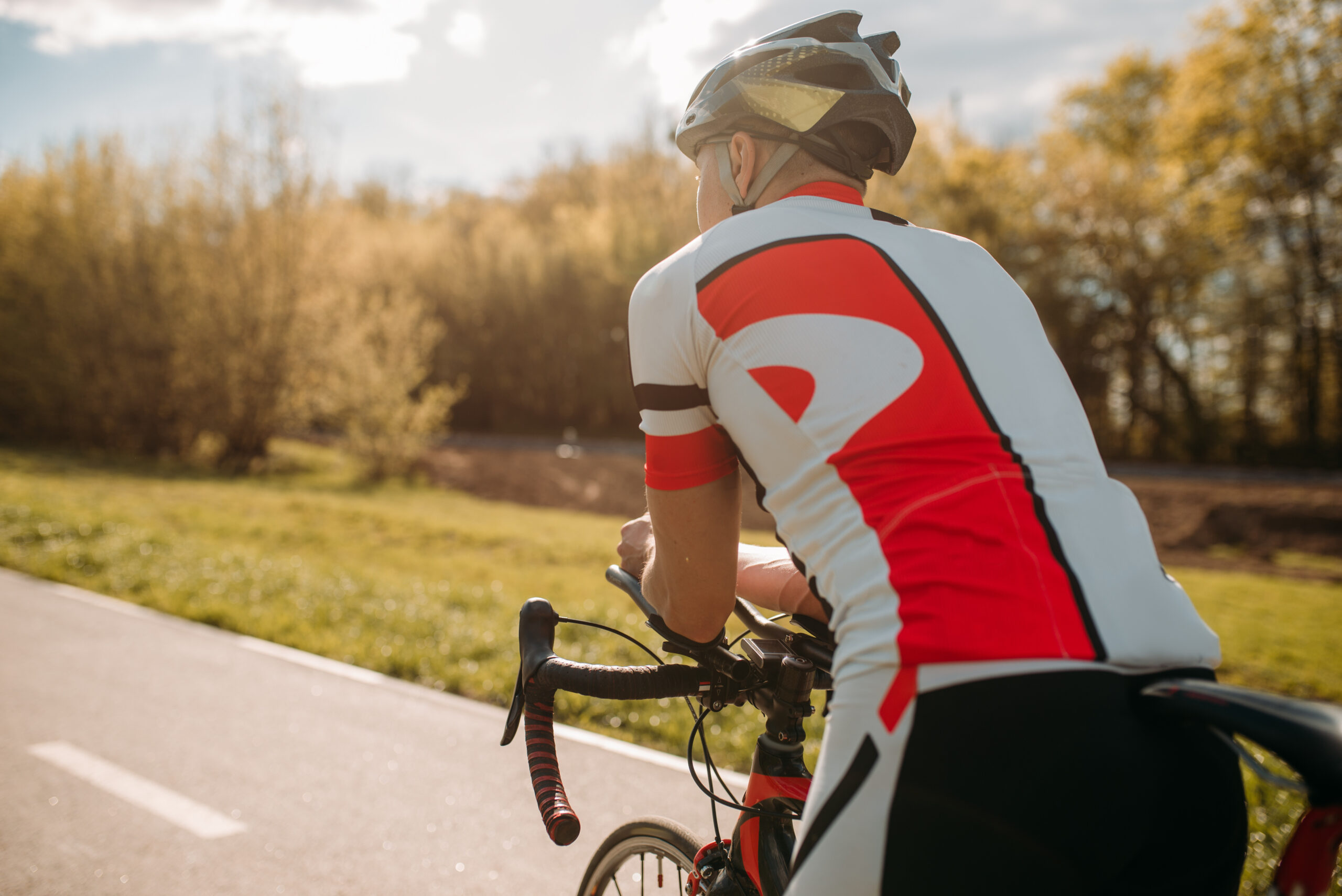 Back view of male cyclist on open road