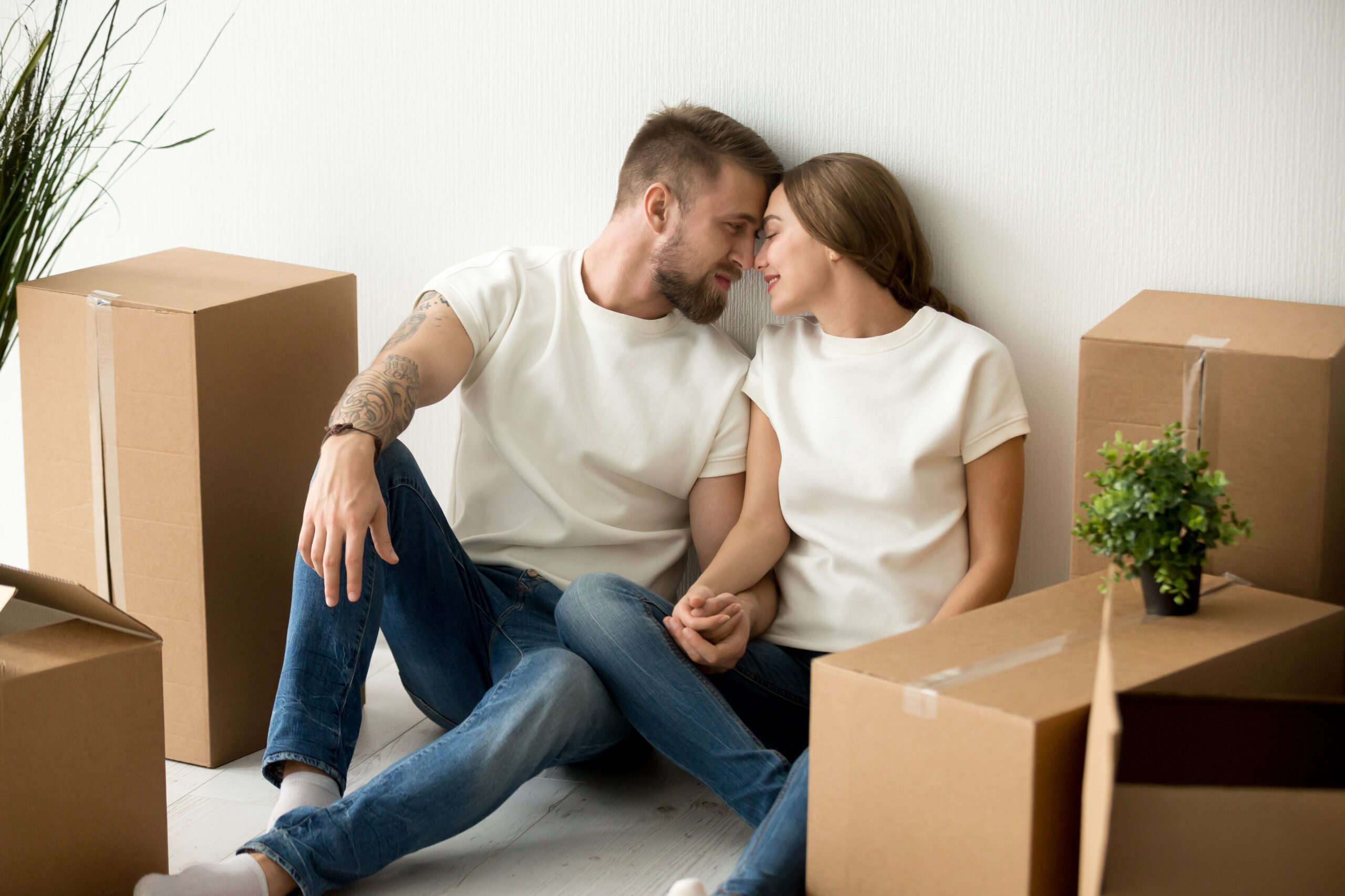 Couple looking at each other, surrounded by moving boxes