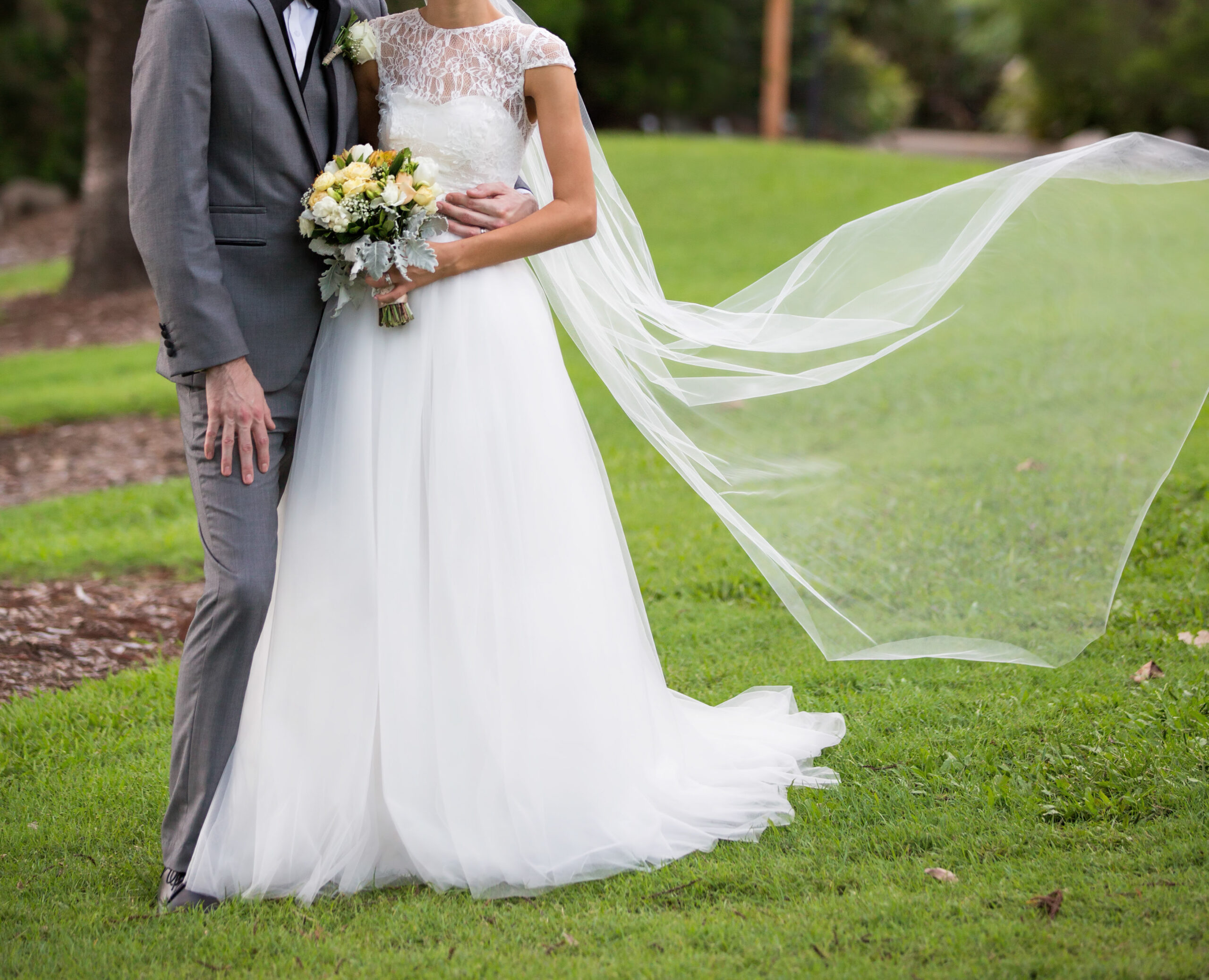 Bride And Groom Pose With Flowing Veil