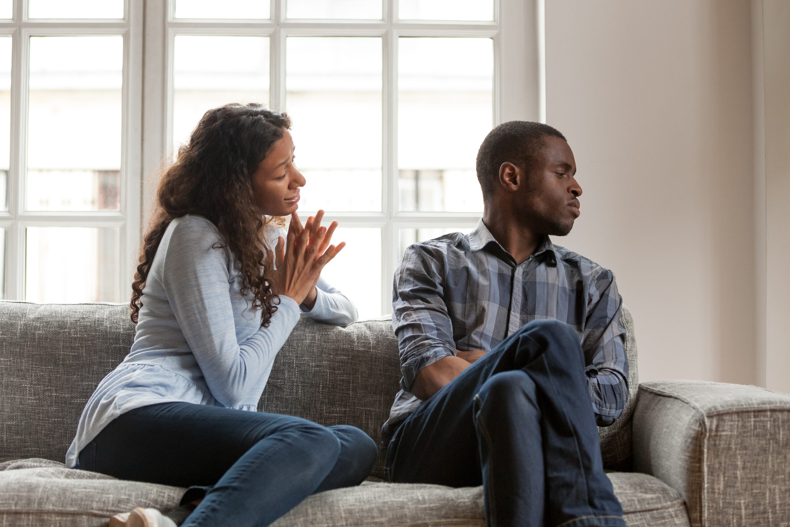 Woman talking to non-listening husband on couch