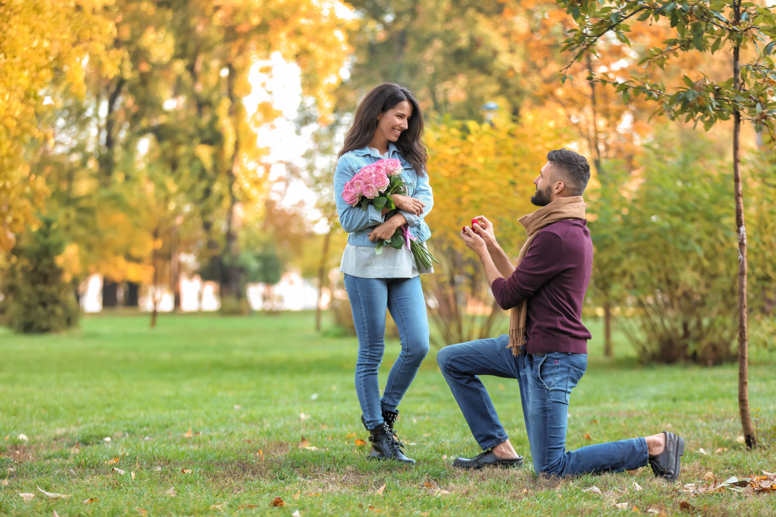 Young man proposing to his beloved in autumn park