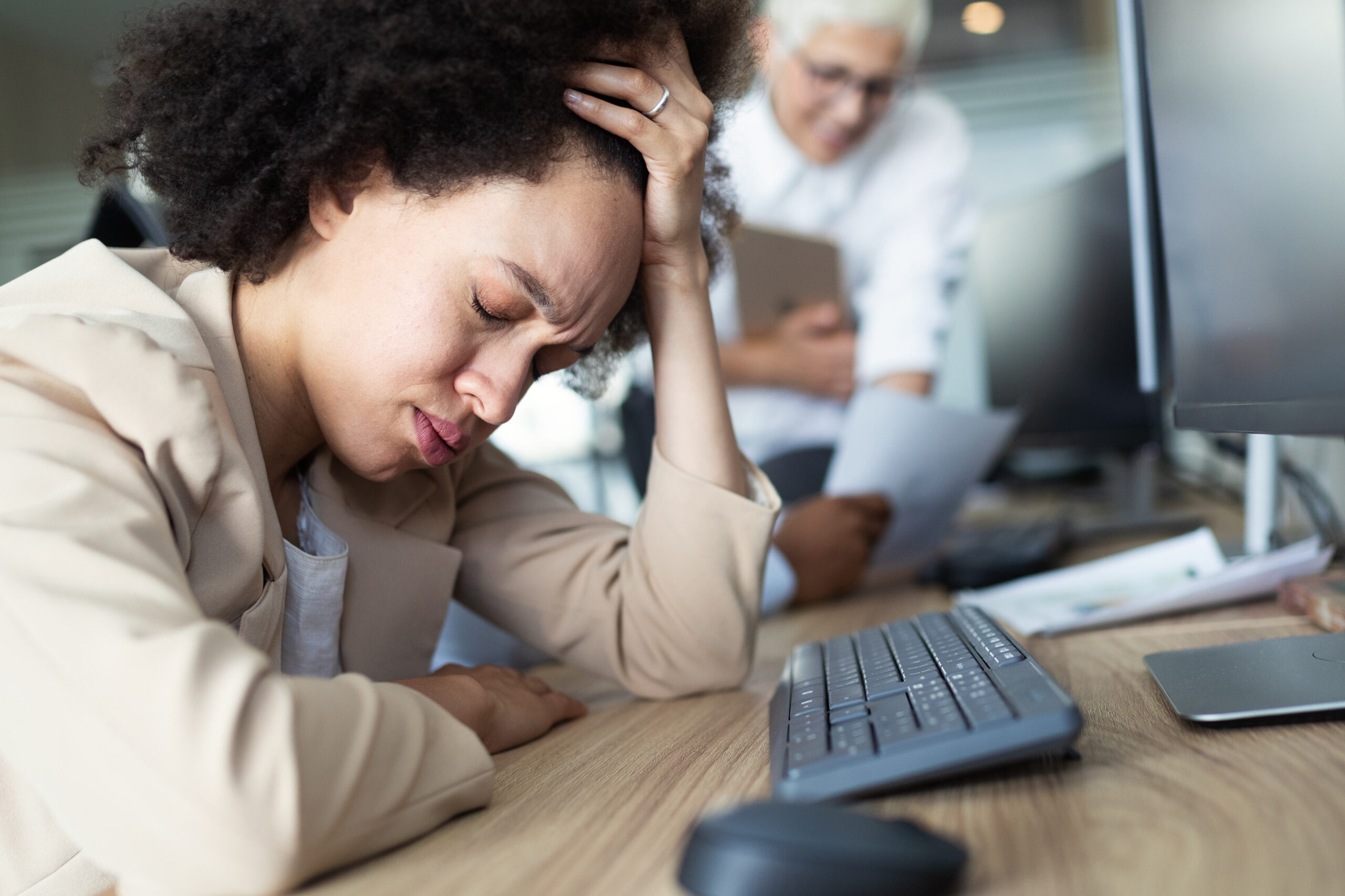 Young african business woman having stress and headache in the office