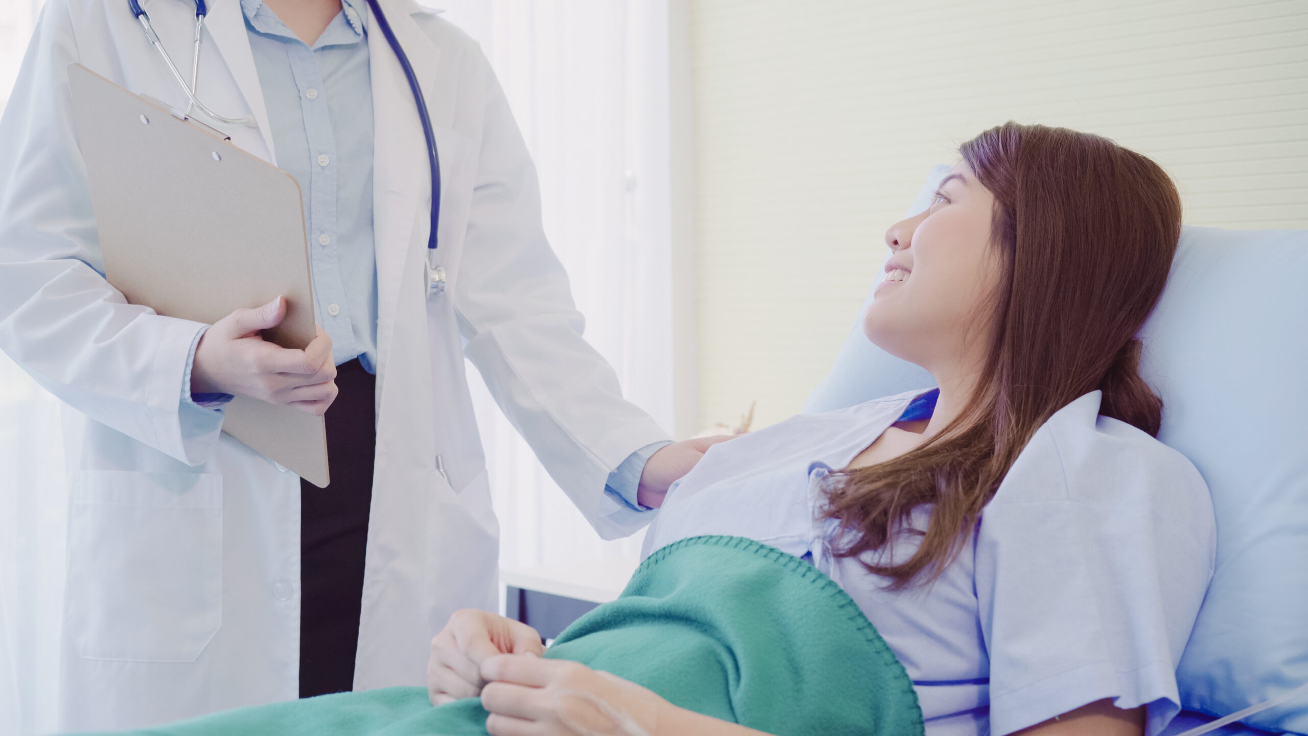 Doctor with female patient in bed