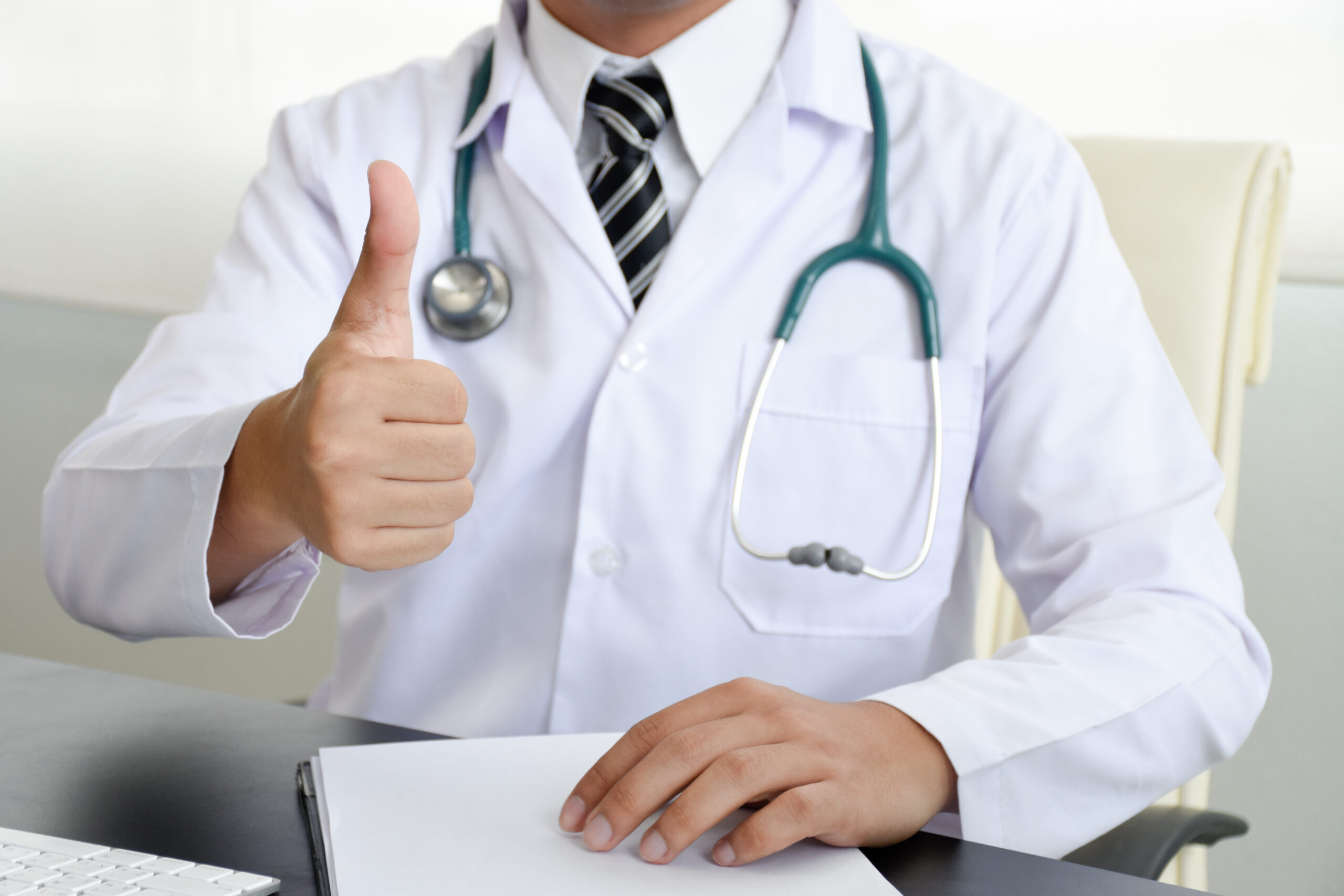 Doctor doing thumbs up at desk