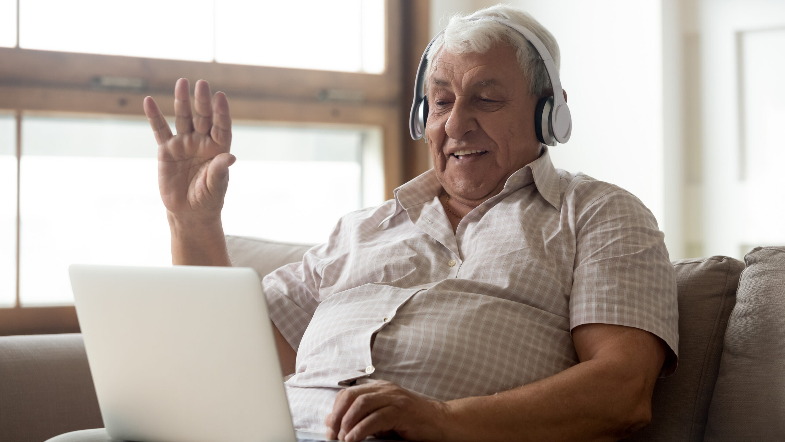 Smiling mature man in headphones have video call