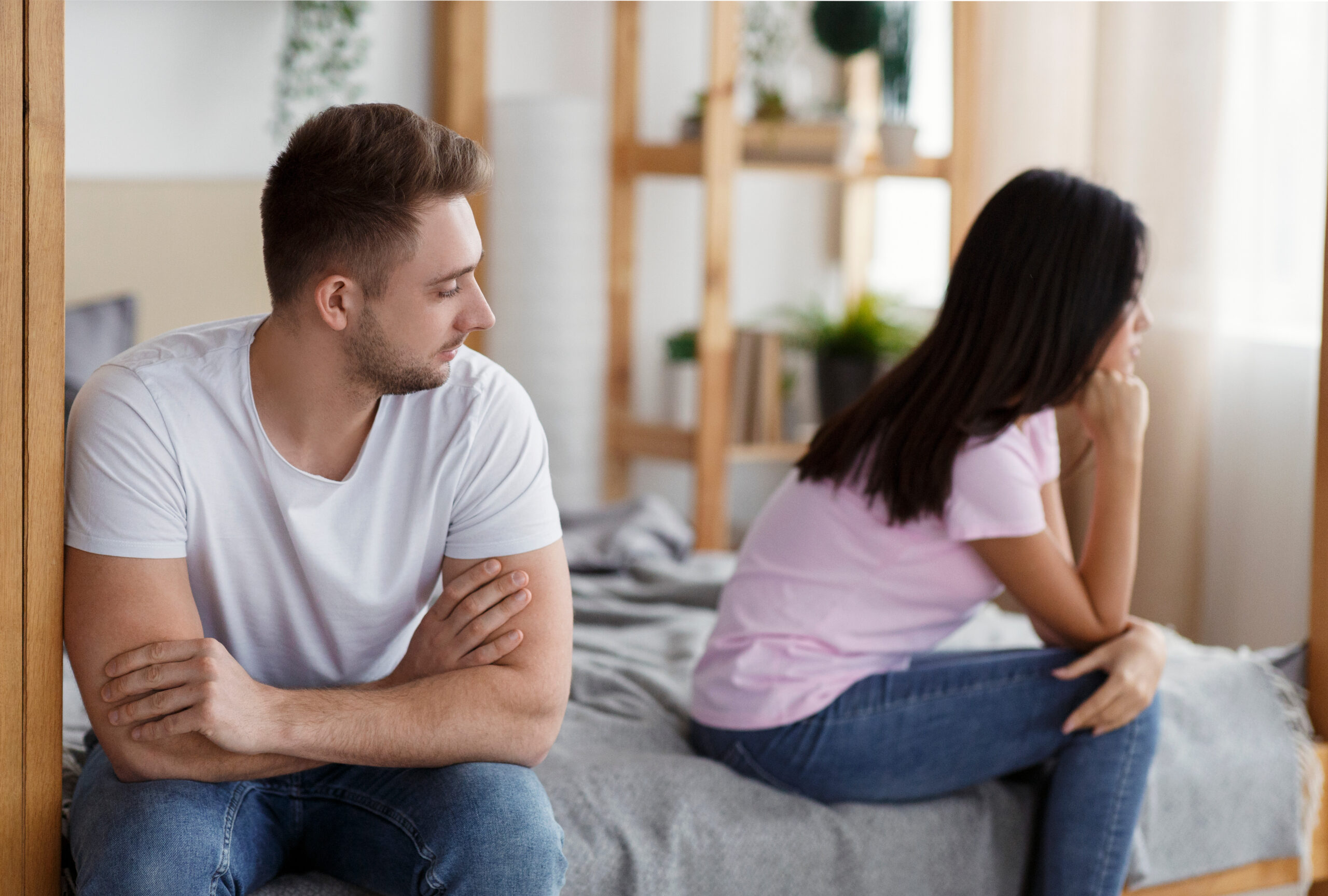 Unhappy Husband And Wife After Quarrel Sitting On Bed