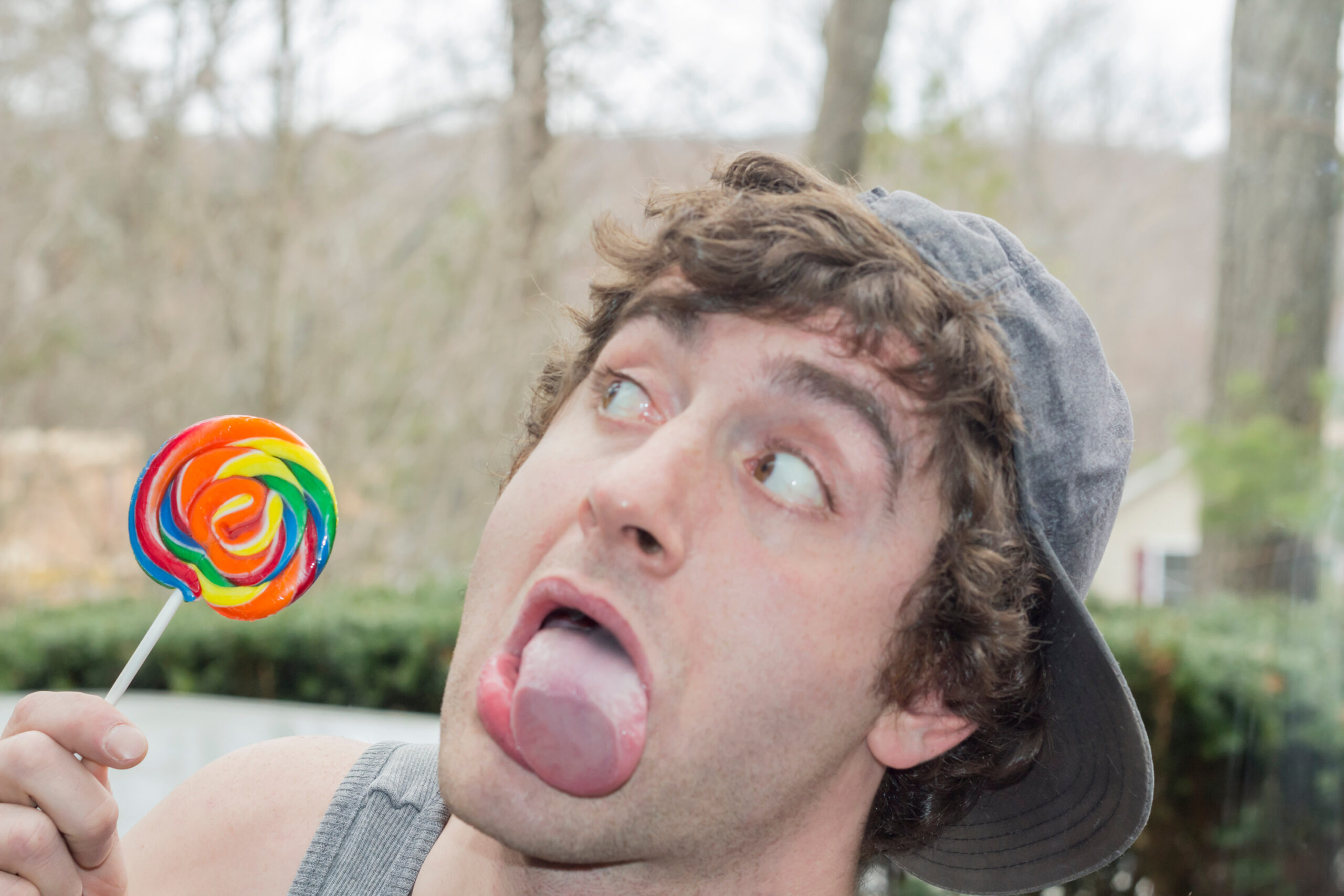 Silly man with lollipop sticking out tongue