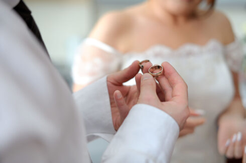 Groom is holding two wedding rings