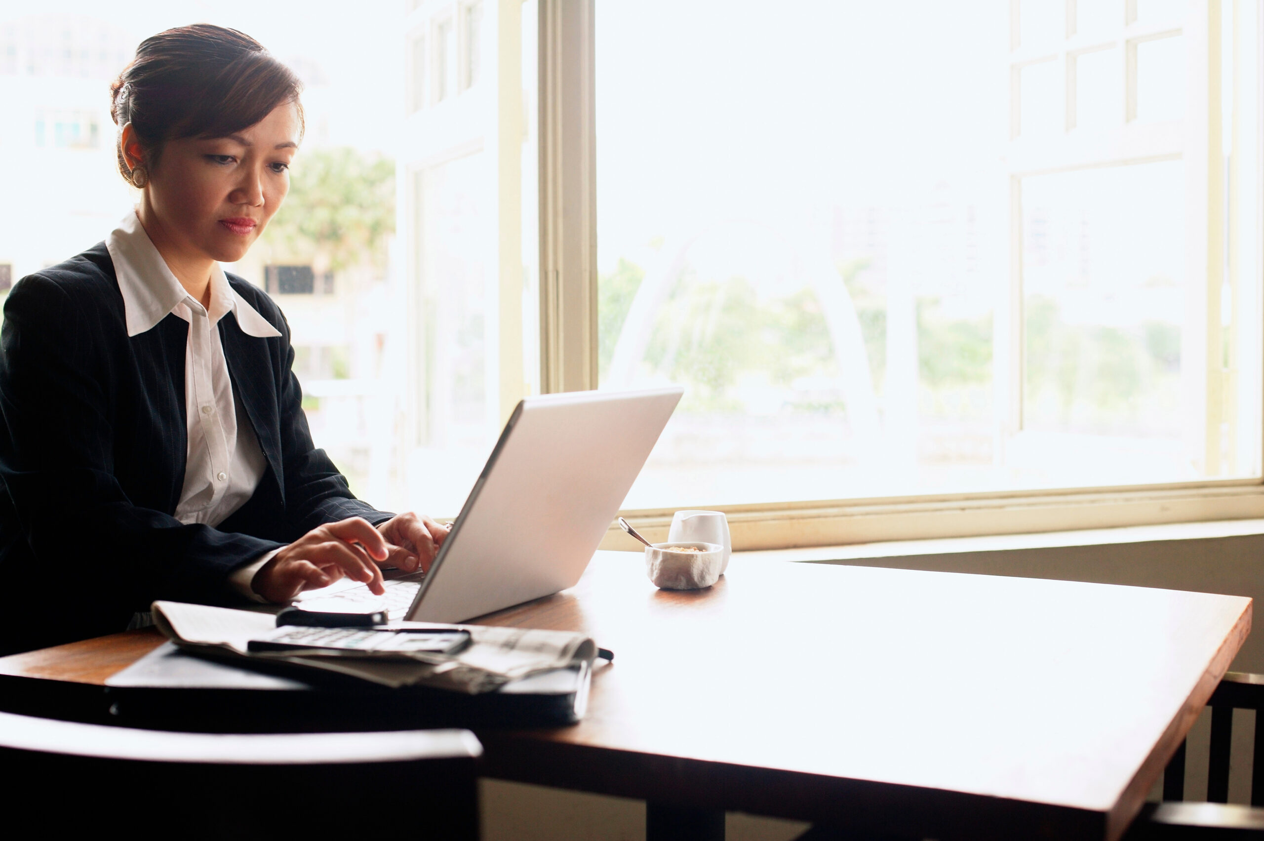 Serious businesswoman on laptop at table