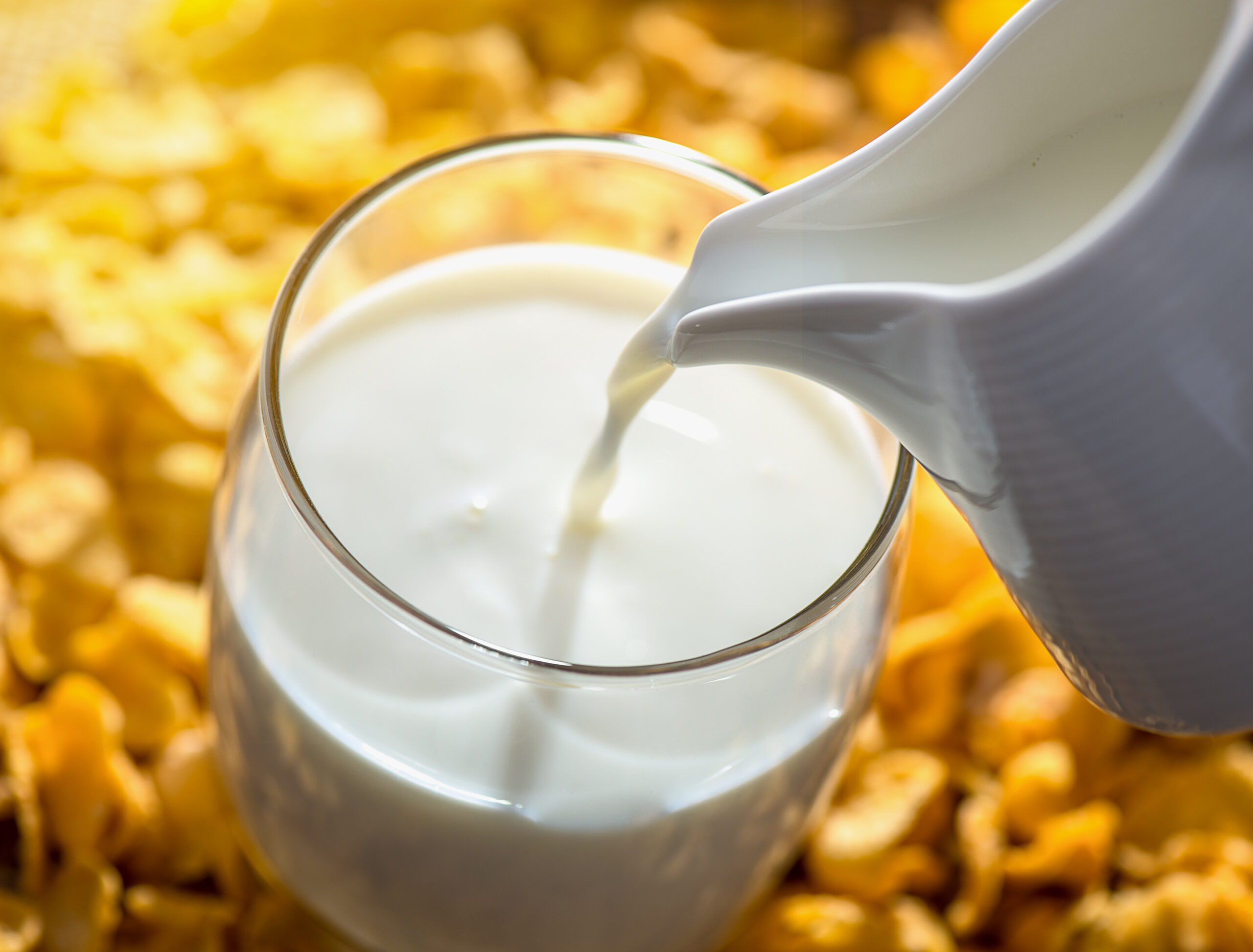 Milk pouring from a jug into a glass